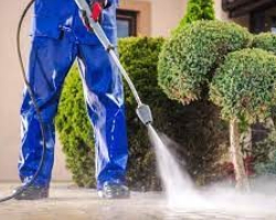 A person pressure-washing a driveway