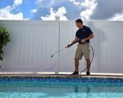 A person power-washing a pool deck