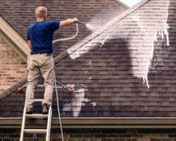 A person washing a roof